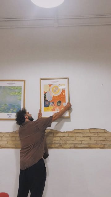Fer colgando sus obras en la pared