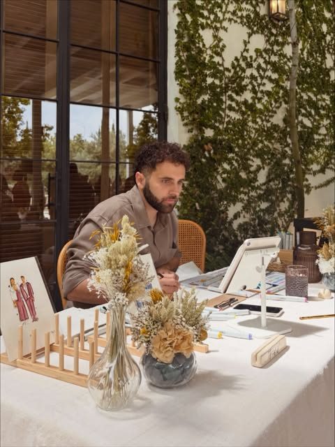 Fer ilustrando en directo en una mesa decorada con flores secas durante una boda